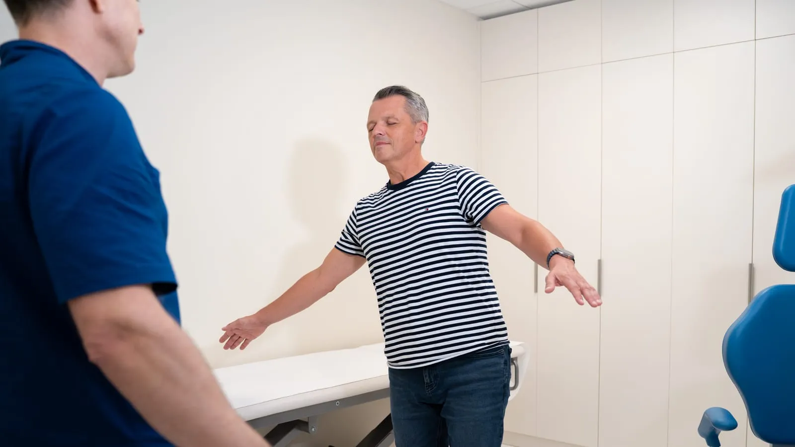Pacient med kliničnim testom ravnotežja (Rombergov test) ob spremljanju specialista